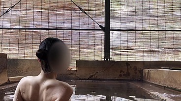 Japanese girl bathing in a mixed outdoor bath at a hot spring inn
