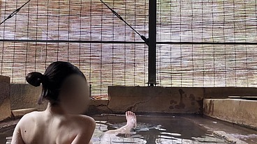 Japanese girl bathing in a mixed outdoor bath at a hot spring inn