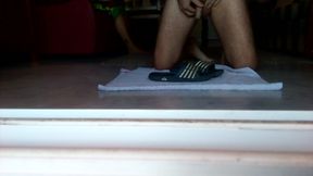 John is peeing on the bathing slippers on the floor