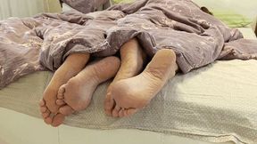 Flirting legs under the blanket a