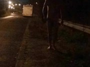 Nude on roadside beside campervan