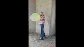 Alla inflates a green crystal balloon with her mouth to the limit and it bursts loudly.