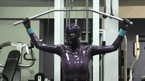 Hot blonde girl in gym makes fitness in purple rubber latex catsuit