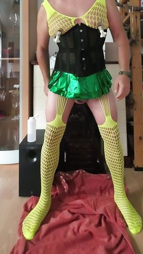 Crossdresser slut in yellow fishnet green miniskirt and black corsage opens his hole with big toys nipple pumps, chastity