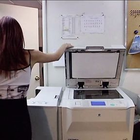 Cute peacheriono with flaming auburn hair  asked her work fellow to explain how to use the new copier