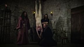 Mooin Witch – The exhausted milkmaid is pulled upside down to the ceiling with weights at her wrists to be tormented and interrogated further and to see milk flowing