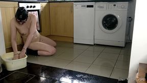slave cleans kitchen floor in chains