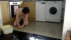slave cleans kitchen floor in chains