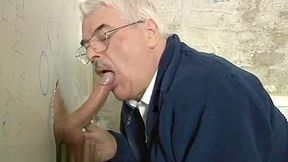 Grey old moustached man giving blowjob through glory hole