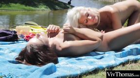 ”Gorgeous lesbians pleasure each other along a lake”