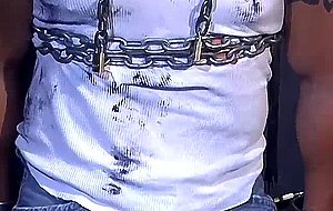 Muscular construction worker is bound up with chains