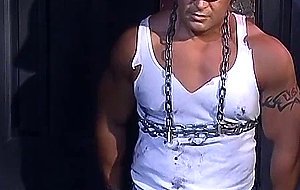 Muscular construction worker is bound up with chains