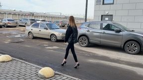 girl in high-heeled shoes and a beautiful pedicure walks through the mud, stains her shoes with mud