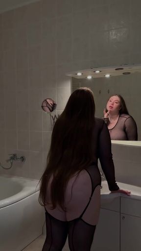 Long-haired woman in lingerie looking at her reflection
