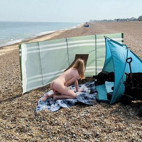 A young blonde wife is nude and masturbating on a British public beach