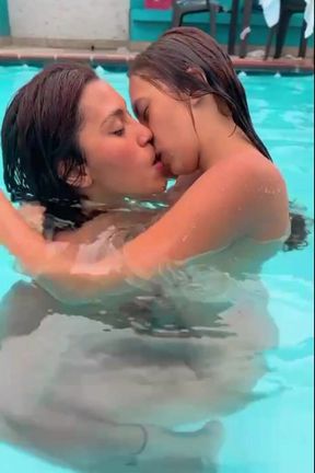 Beautiful lesbian couple having a good time in the pool