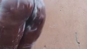 Beautiful African girl bathing outdoors