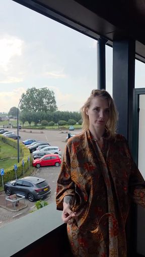 Woman in robe standing by window