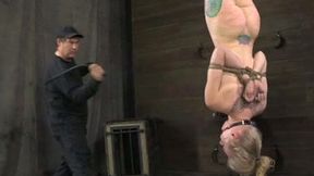 Trashy blonde with tattoos is hanging upside down in the dungeon