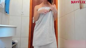 Saindo do banho s&oacute_ de toalha dan&ccedil_ando e  passando creme no corpo