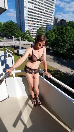 Pointing on the balcony in lingerie