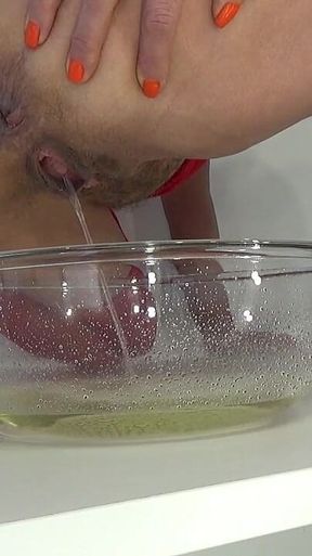 A MILF in Red Is Peeing Into a Basin.