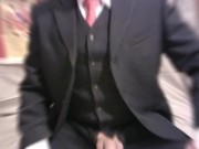 corbata roja, traje azul marino con chaleco mostrando miembro