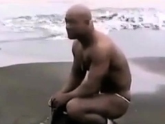 Asian bodybuilder barely covered at the beach