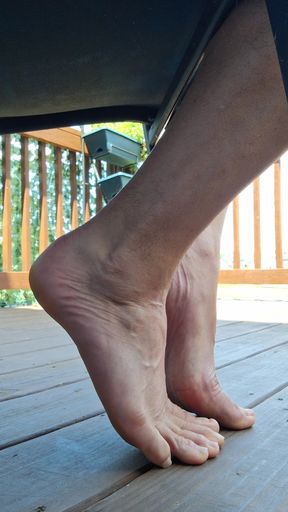 Sneak shot of my feet soles toes barefoot under a chair