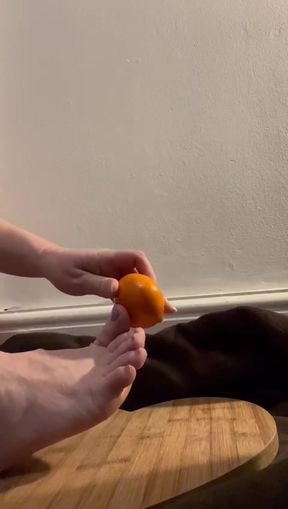Bare feet crushing and orange