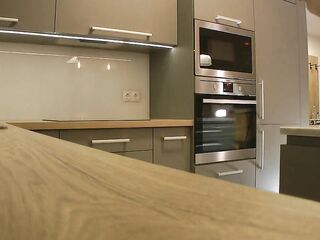 Lengthy hair lengthy legs sexy golden-haired college cutie on high heels and a miniskirt which does not cover her butt in the kitchen