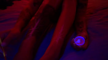 Amelia se masturba mientras su cuerpo tatuado se estremece de placer, terminando envuelta en luces y pintura brillante que hacen de su piel una obra viva de deseo.