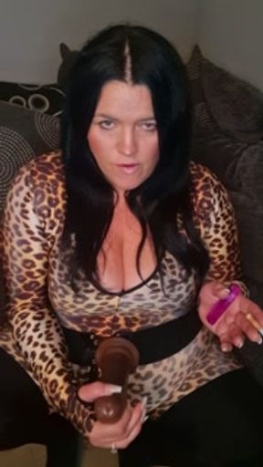 MILF SMOKES CIGARETTES IN CATSUIT WHILE RIDING HUGE DILDO