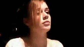 This naked teenage chick sits with no expression on her face