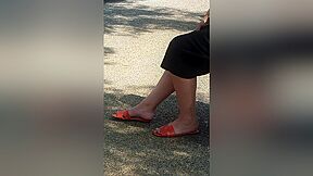 Candid Legs And Feet In Orange Sandals Of A Brunette Woman At The Bus