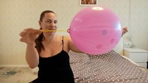 Inflating a pink punch ball until it bursts a