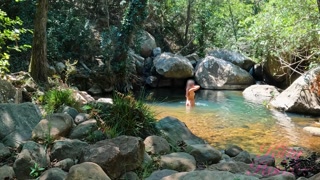 VOYEUR ON A GIRL BATHING IN A SUNNY STREAM