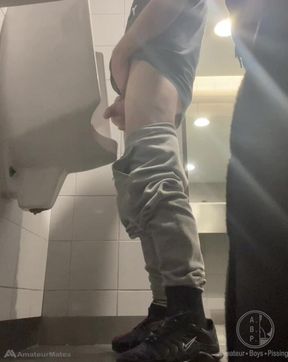 2 Boys in Sneakers Having Fun at Public Toilets' Urinal