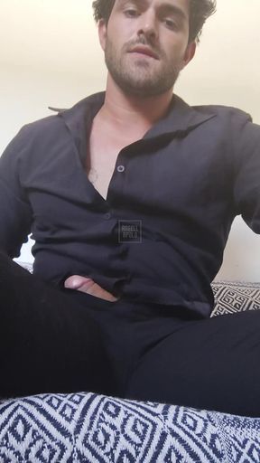 Tattooed in social clothes having fun alone on his couch