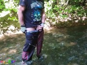 German guy stands in a creek, pisses and jerks off his hard cock
