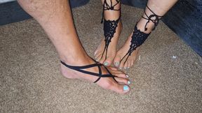 Playing footsie while wearing black strappy barefoot jewelry