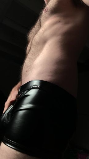 Curvy girl in leather underwear shows off her stomach