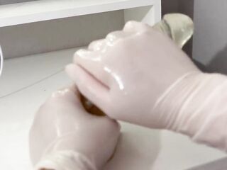 I give a tugjob to the sex tool with oily hands in medical white gloves