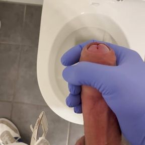 Jerking doctor at a toilet with latex gloves