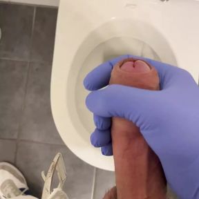 Jerking doctor at a toilet with latex gloves