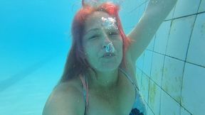 Blowing bubbles underwater in dress