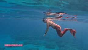 Carissa mermaiding in the Red Harlot tail in the Pacific Ocean