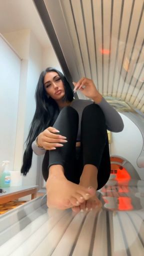 Gym goddess gets her soles out on the sunbed