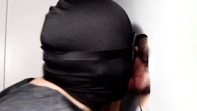 Masked gimp massages those balls while sucking cock through gloryhole