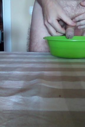 John is peeing into a green bowl on the table
